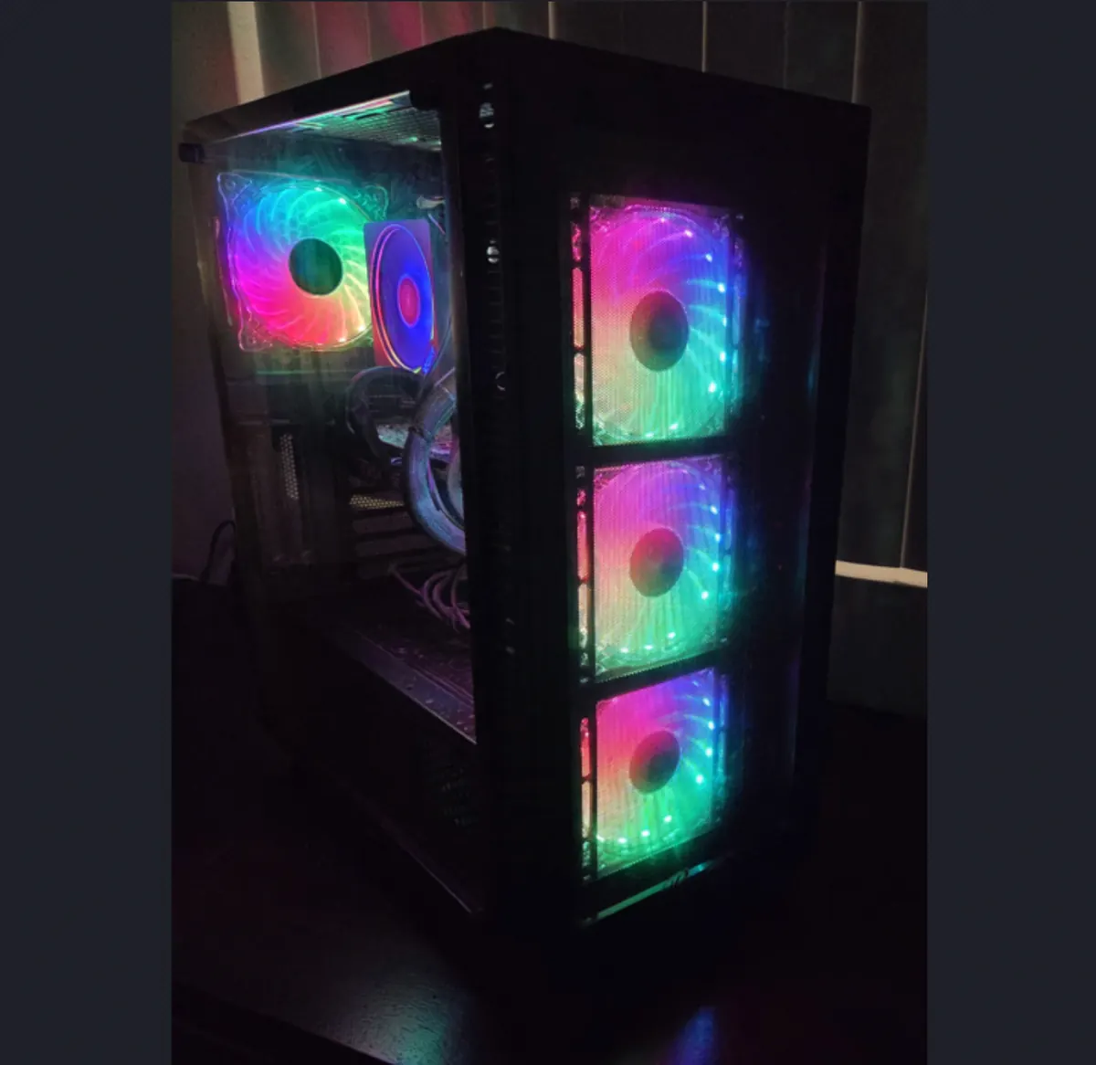 Front three-quarter view of an RGB gaming PC with three illuminated intake fans